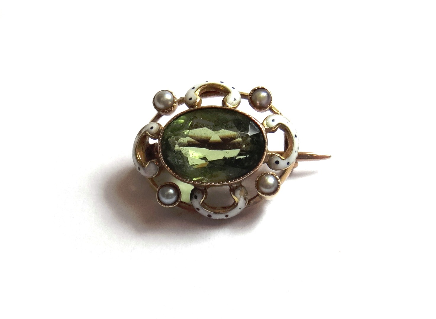 Appraisal: A gold peridot and enamelled small oval brooch collet set