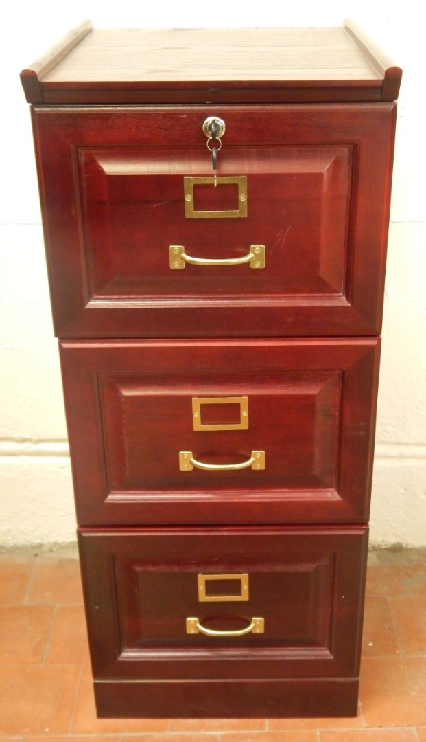 Appraisal: A reproduction stained oak filing cabinet with three drawers and