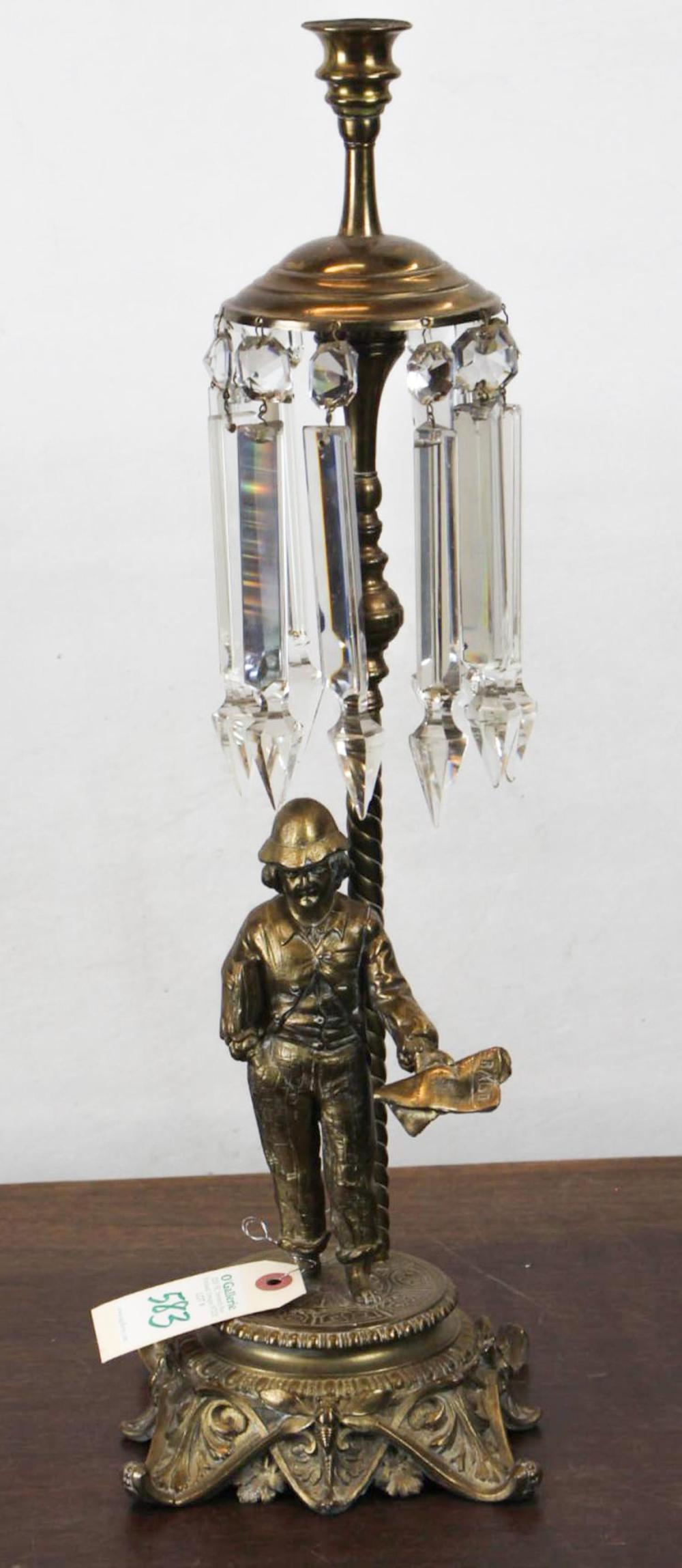 Appraisal: LATE VICTORIAN FIGURAL BRASS CANDLESTICK HOLDER boy selling newspapers under