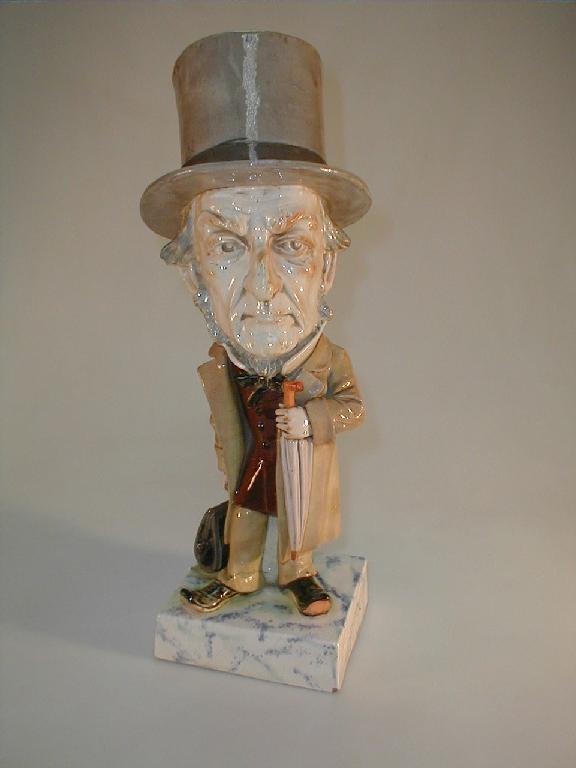 Appraisal: A glazed pottery caricature figure of William Ewart Gladstone wearing