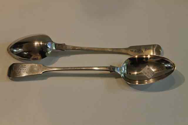 Appraisal: TWO FIDDLE PATTERN SILVER SERVING SPOONS both monogrammed London Newcastle