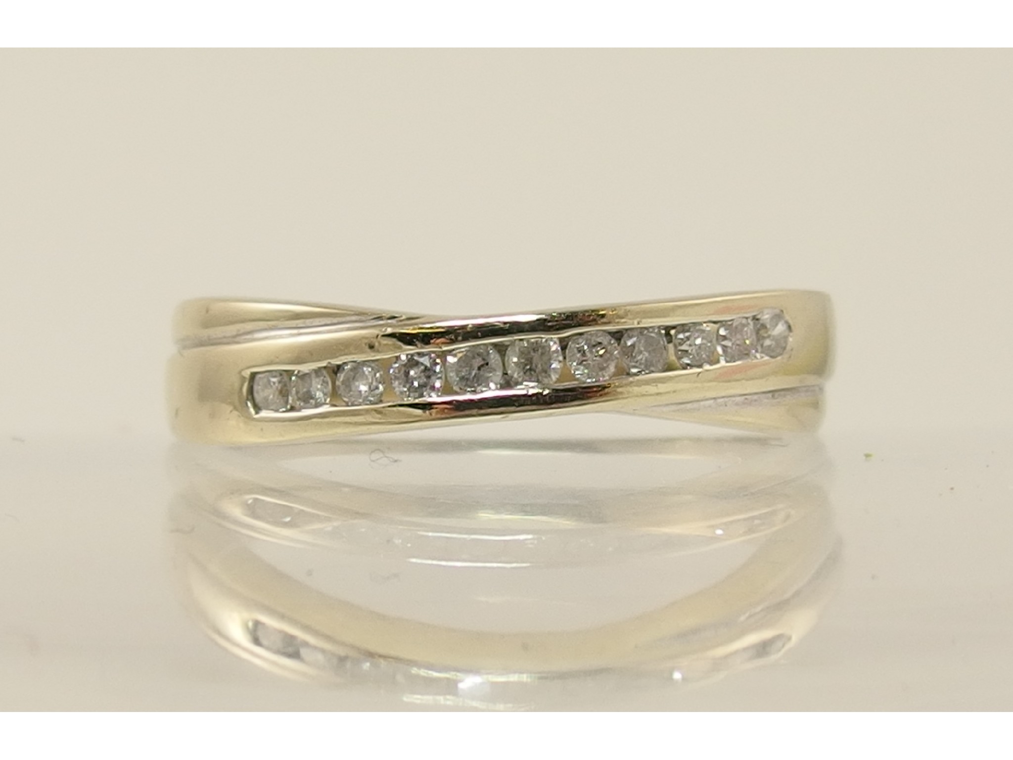 Appraisal: An ct channel set diamond cross over band ring with