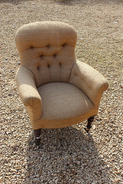 Appraisal: A VICTORIAN BUTTON UPHOLSTERED ARMCHAIR with shaped back scroll arms