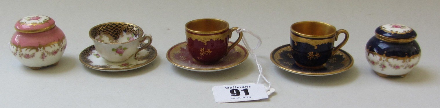 Appraisal: Three Coalport miniature cups and saucers each gilt decorated against