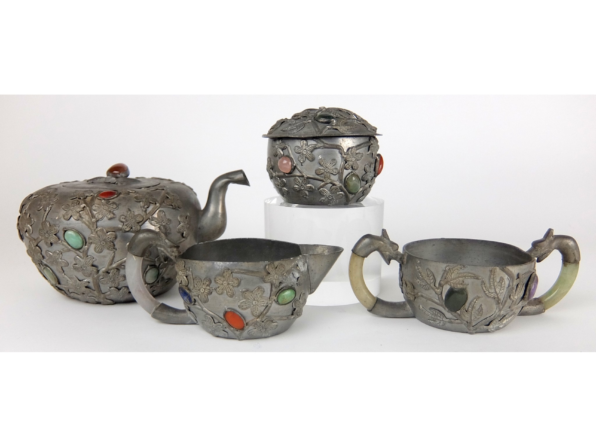 Appraisal: A Chinese pewter four piece tea servicecast with flowers and