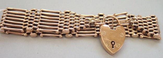 Appraisal: A gold bar and decorated oval link gate bracelet on