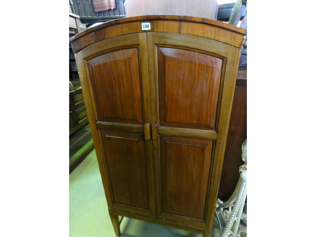 Appraisal: A walnut side cupboard of arched top form enclosed by