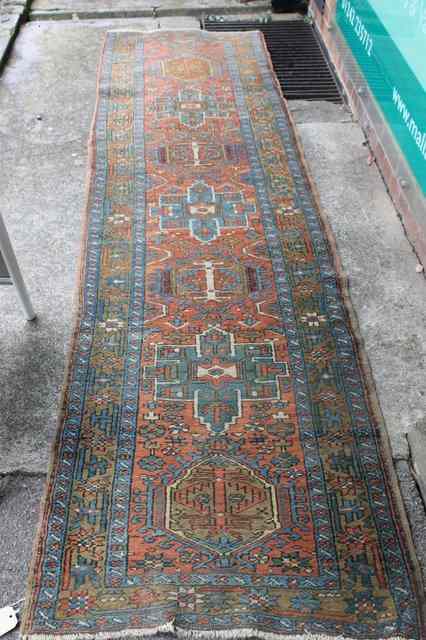 Appraisal: AN HAMADAN RED GROUND RUNNER with central medallions within a