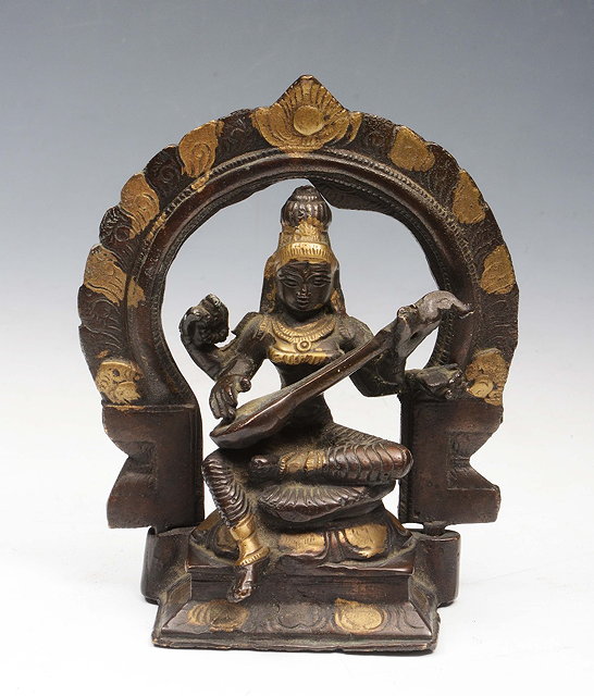 Appraisal: AN ANTIQUE EASTERN BRONZE OF A DEITY playing a sitar