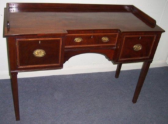 Appraisal: A mahogany kneehole sideboard fitted a central drawer flanked by