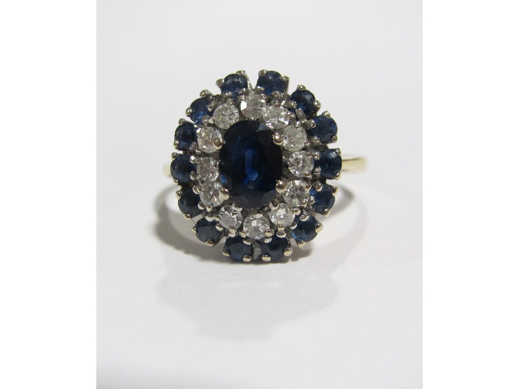 Appraisal: An eighteen carat gold sapphire and diamond cluster ring with