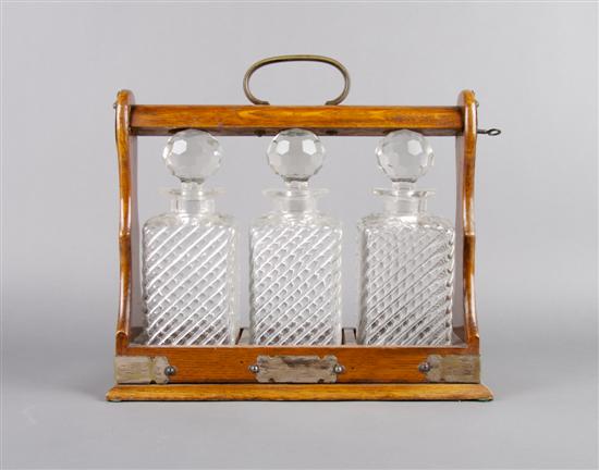 Appraisal: An English Oak and Glass Three Bottle Tantalus Width inches