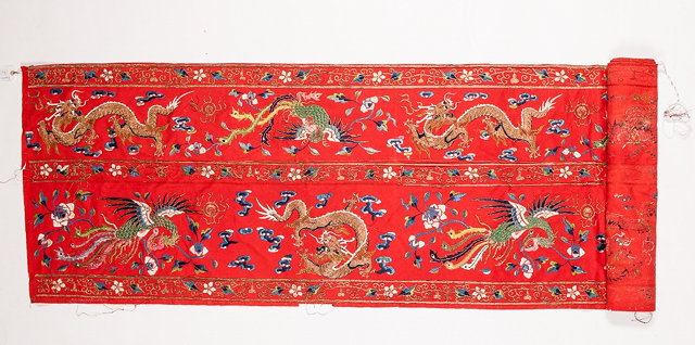 Appraisal: A CHINESE RED BROADCLOTH with long rectangular panel depicting lyre