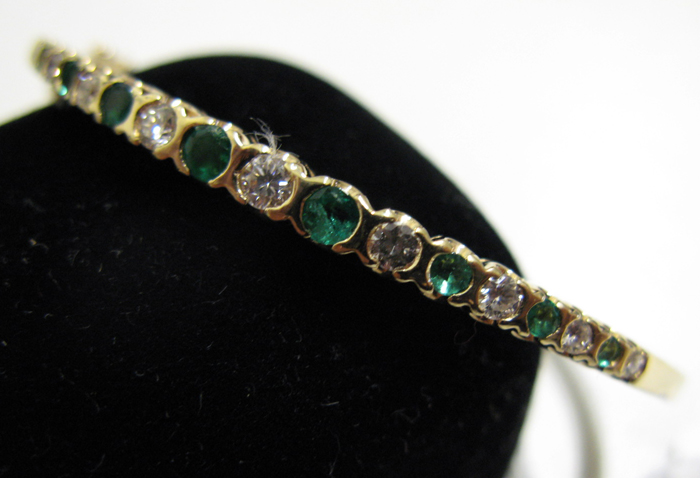 Appraisal: EMERALD DIAMOND AND FOURTEEN KARAT GOLD BANGLE set with nine