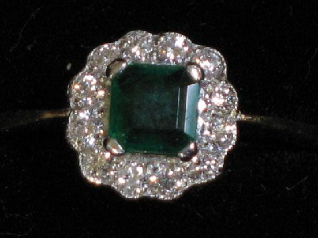 Appraisal: AN EMERALD AND DIAMOND CLUSTER RING the central claw-set princess-cut