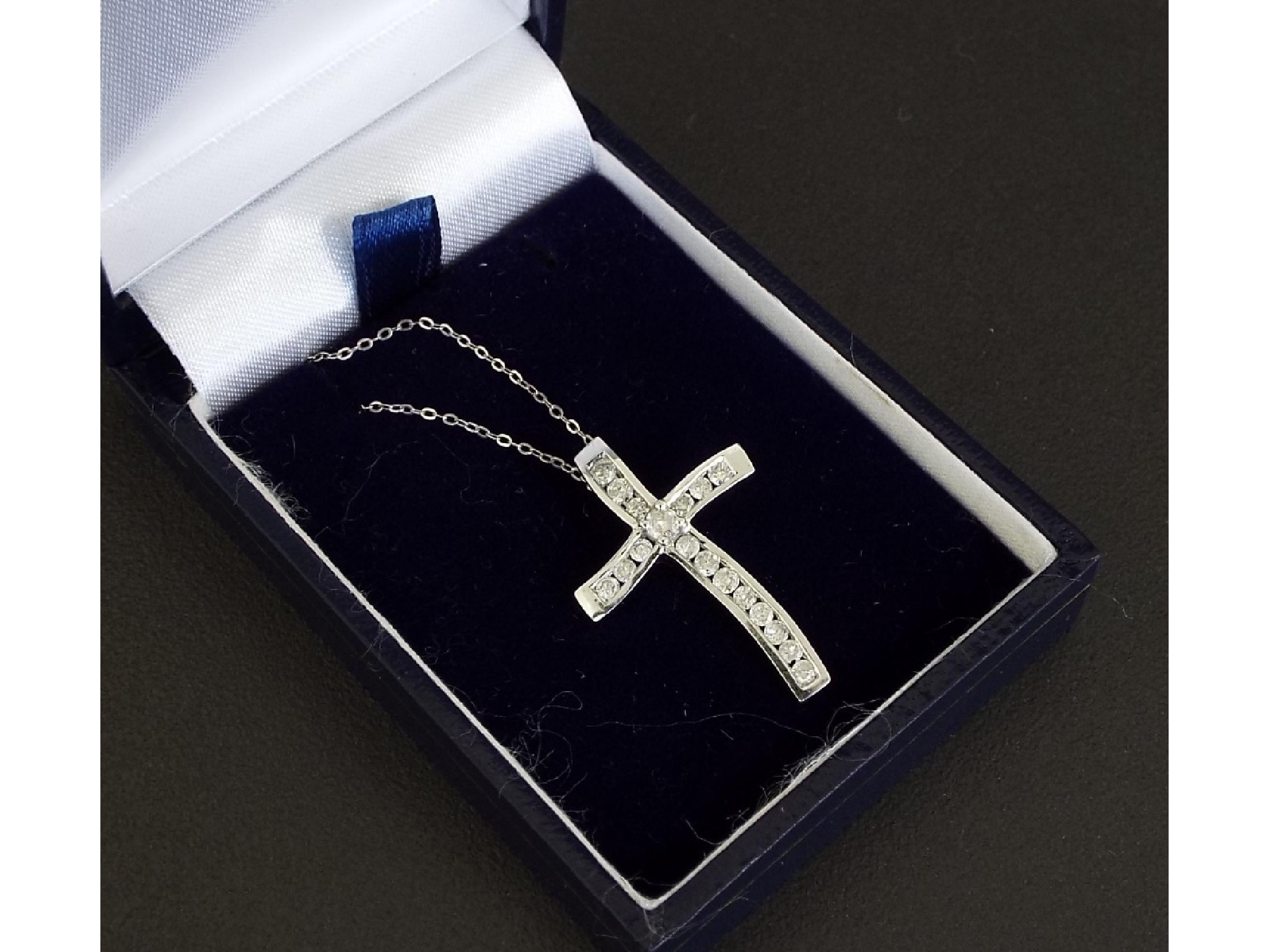 Appraisal: White gold diamond cross pendant on a slender ct trace