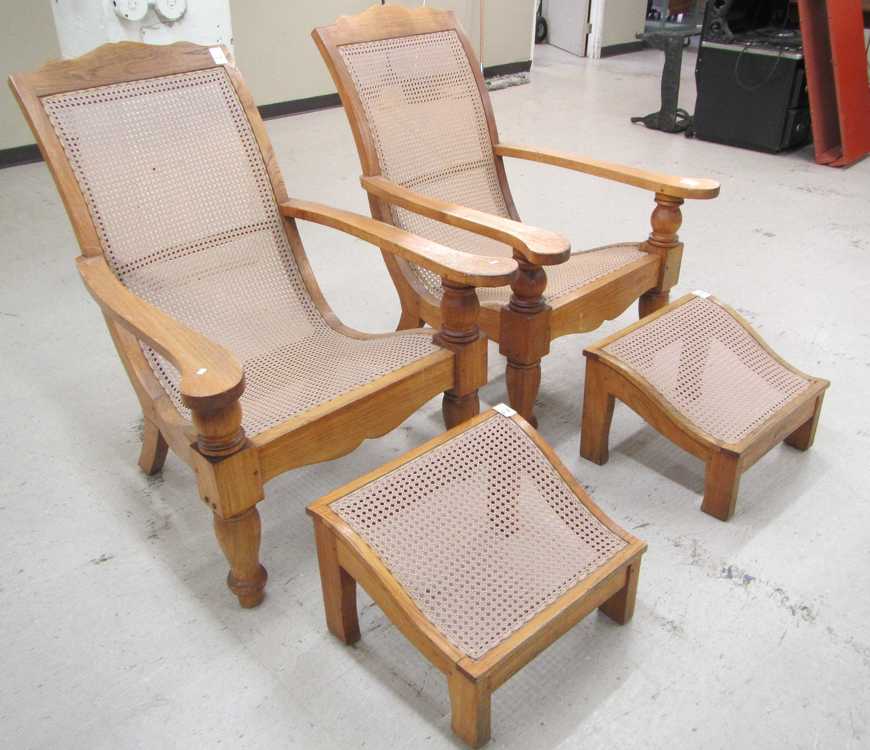 Appraisal: A SET OF FOUR TEAK PLANTATION ARMCHAIRS AND THREE FOOTSTOOLS