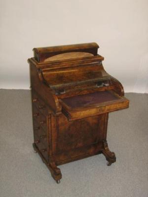 Appraisal: A VICTORIAN WALNUT PIANO TOP DAVENPORT the moulded edged top