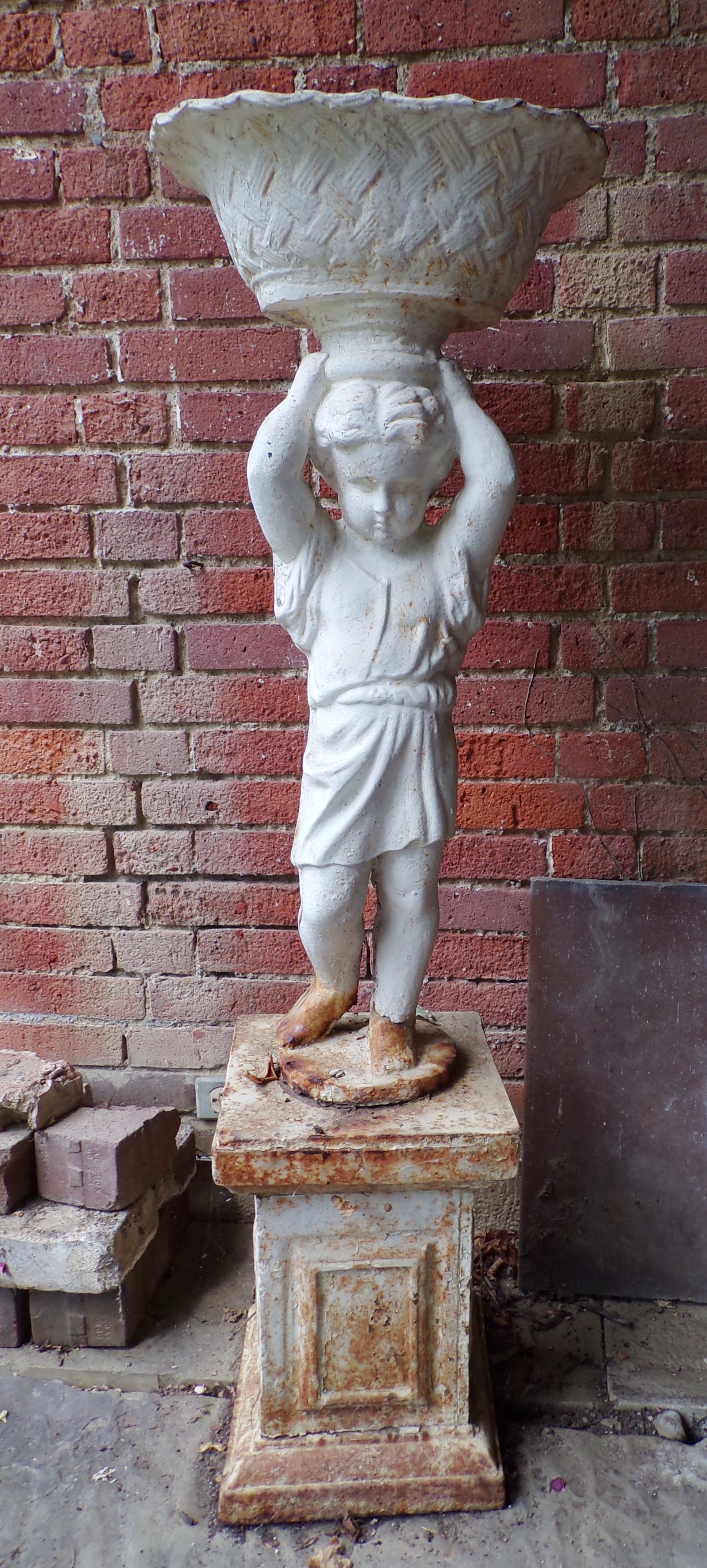 Appraisal: Cast iron garden statue- child holding a basket ''h