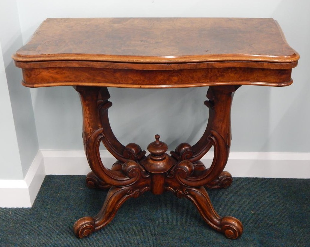 Appraisal: A Victorian burr walnut card table the hinged shaped top