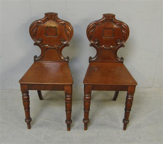 Appraisal: Pair of th century mahogany hall chairs with carved shaped