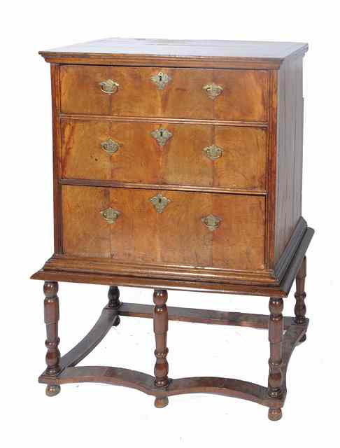 Appraisal: A GEORGIAN WALNUT CHEST ON STAND with three graduated long