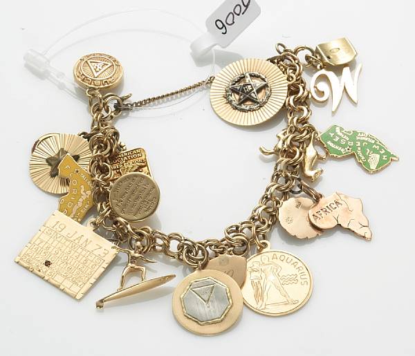 Appraisal: A k and k gold charm bracelet suspending twenty charms