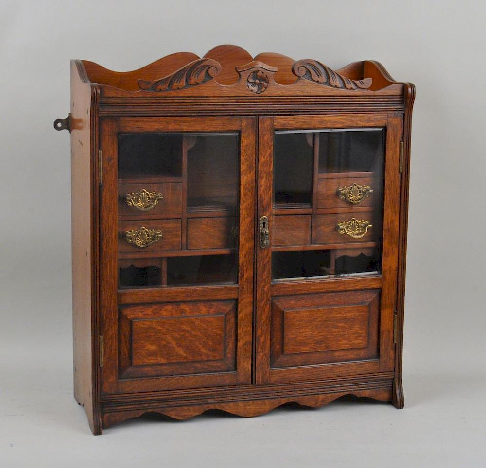 Appraisal: Large English Mixed Woods Tobacco Cabinet having beveled glass doors