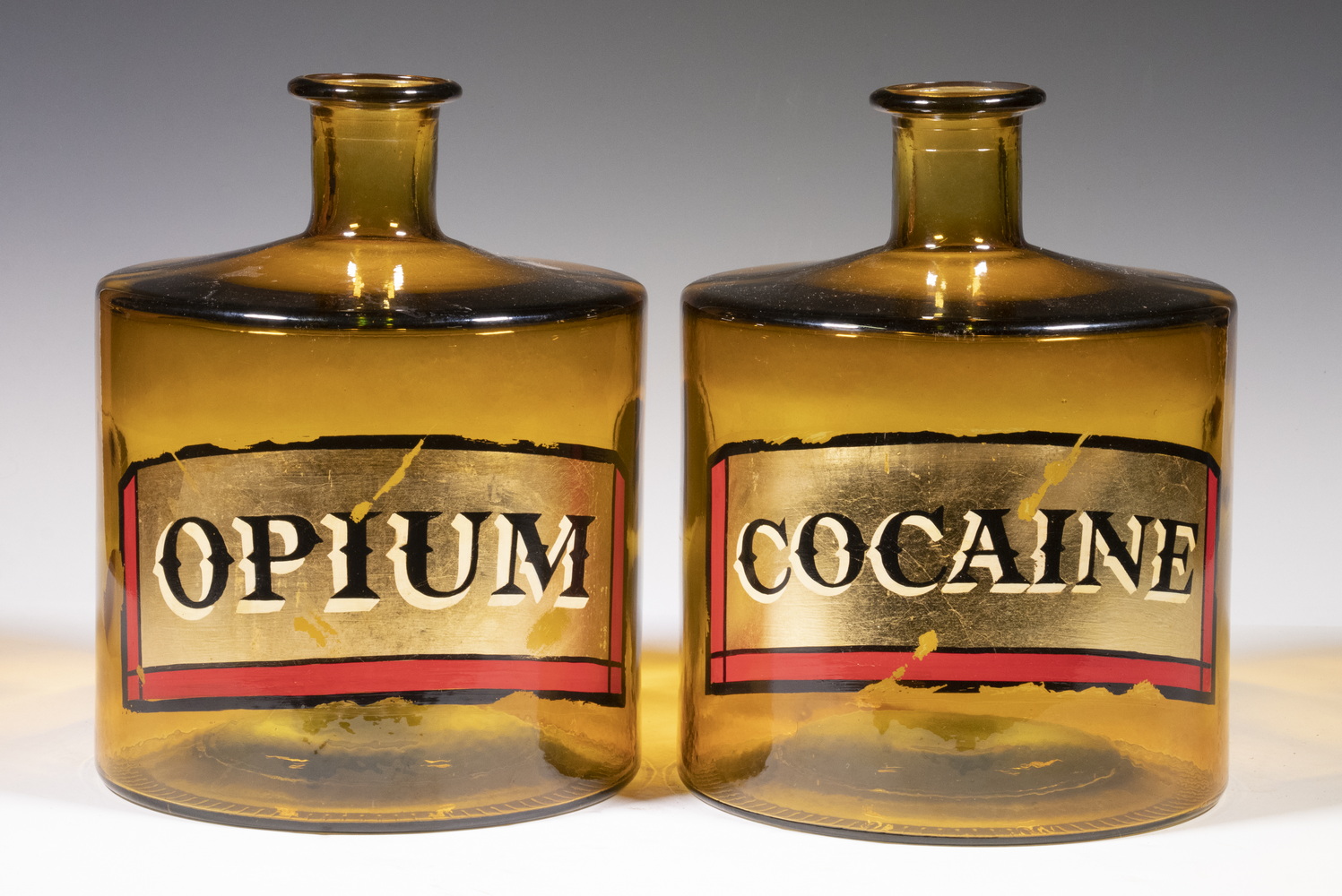 Appraisal: PAIR BROWN GLASS APOTHECARY JARS COCAINE OPIUM Medium-Sized Molded Cylindrical