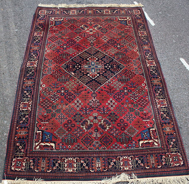 Appraisal: AN EASTERN RUST GROUND RUG with a central diamond shaped