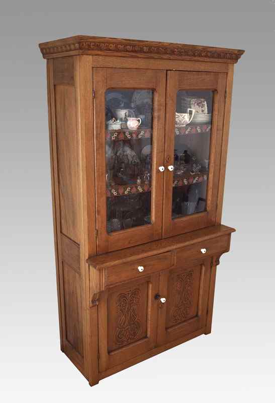 Appraisal: AMERICAN LATE VICTORIAN OAK CUPBOARD Carved pediment over glass doors