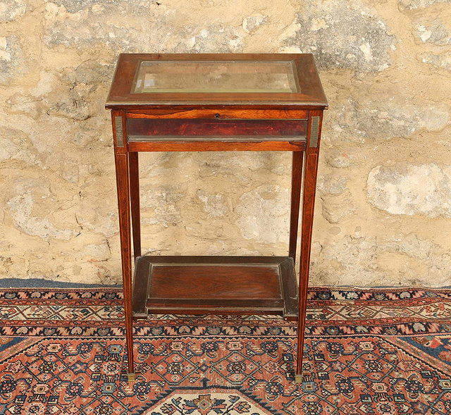 Appraisal: A VICTORIAN ROSEWOOD BIJOUTERIE TABLE brass mounted with bevelled glazed