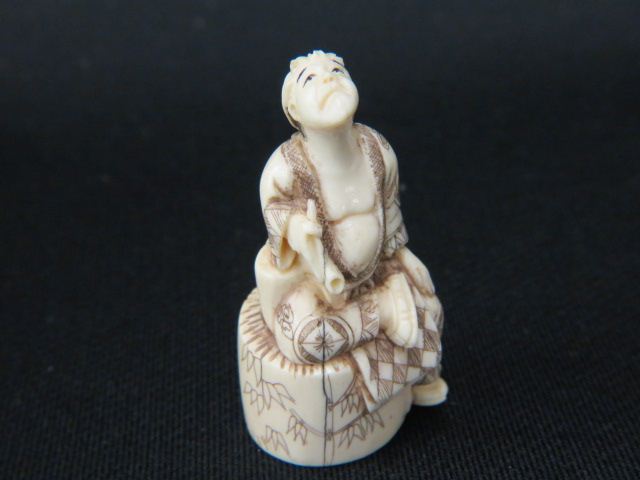 Appraisal: Carved Ivory Netsuke of Man holding a pipe looking upwards