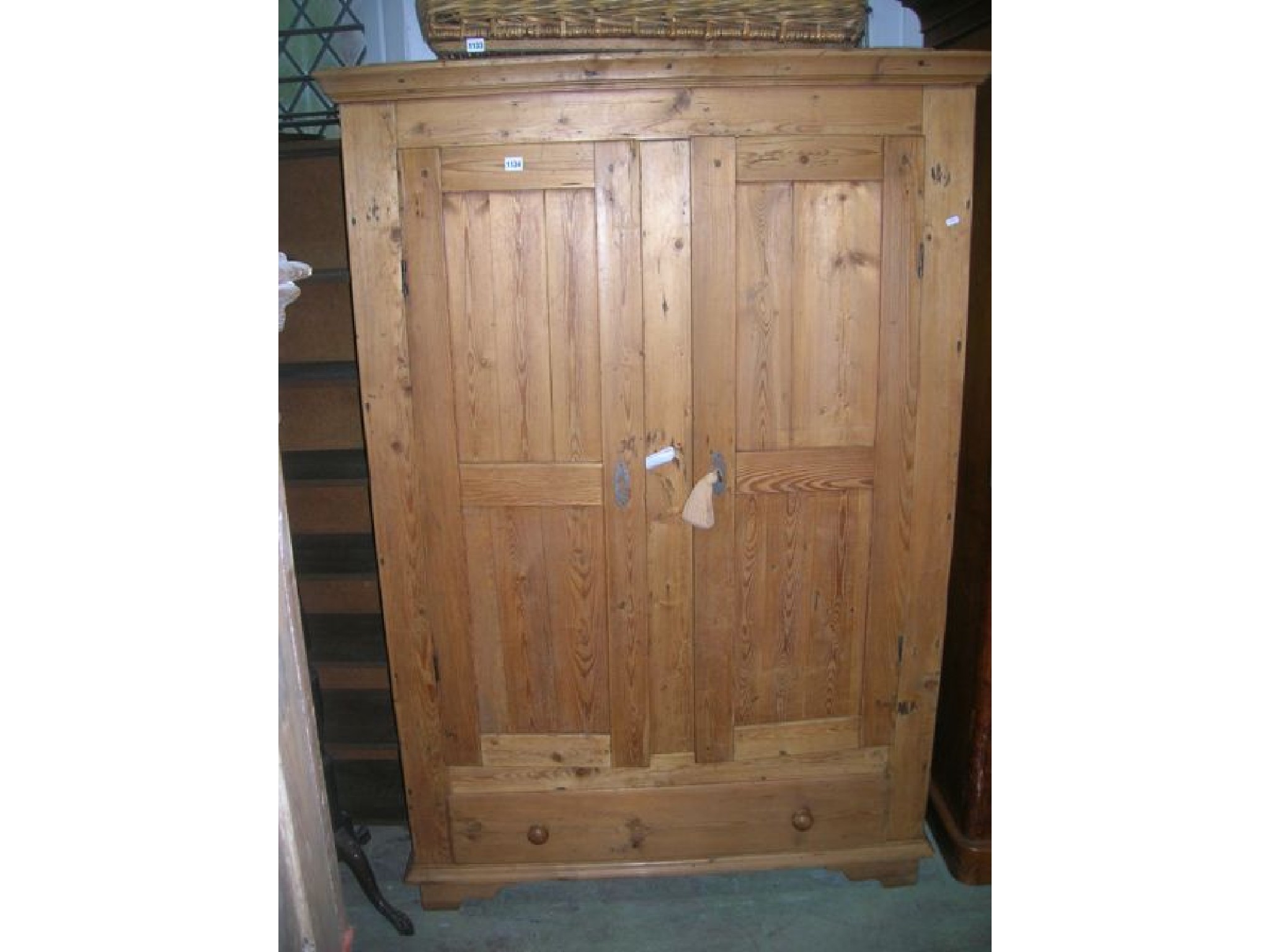 Appraisal: A continental stripped pine wardrobe partially enclosed by a pair