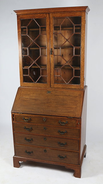 Appraisal: AN OAK BUREAU BOOKCASE the astragal glazed doors enclosing adjustable