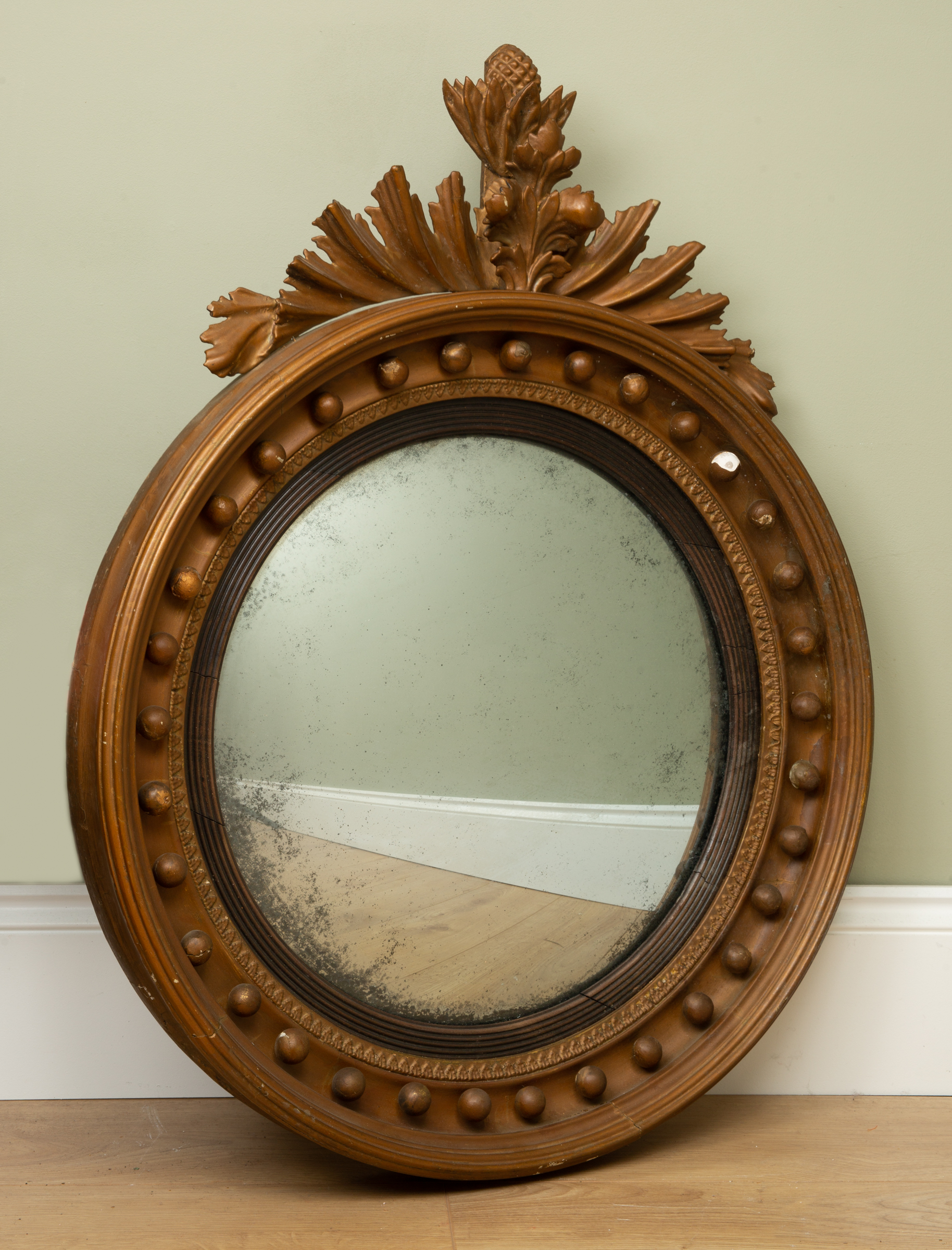 Appraisal: A th century circular convex mirror gold painted and with