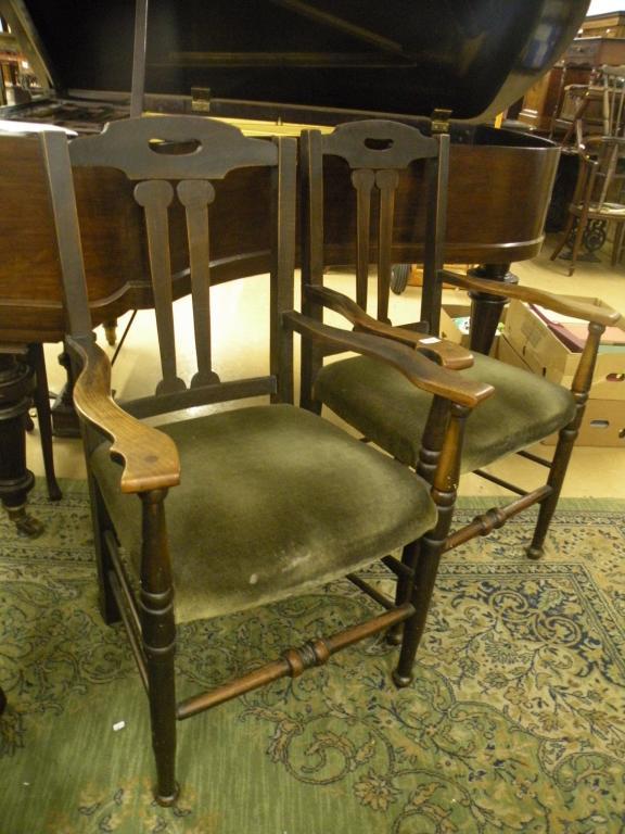 Appraisal: A pair of oak open armchairs each with a green