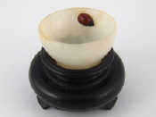 Appraisal: A small turned white hardstone bowl with brown and black