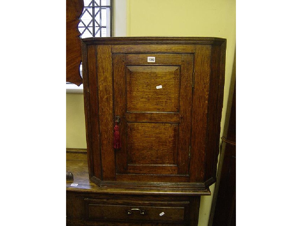 Appraisal: A small Georgian oak hanging corner cupboard enclosed by a