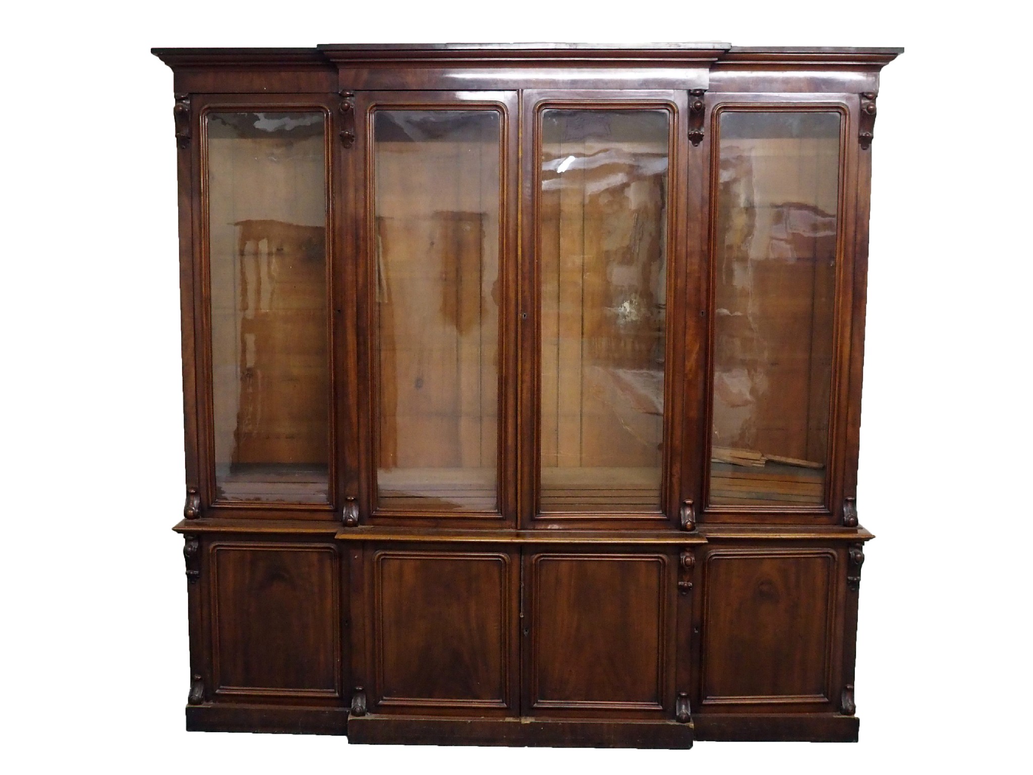 Appraisal: A Victorian mahogany breakfront bookcasethe overhanging cornice above four glazed