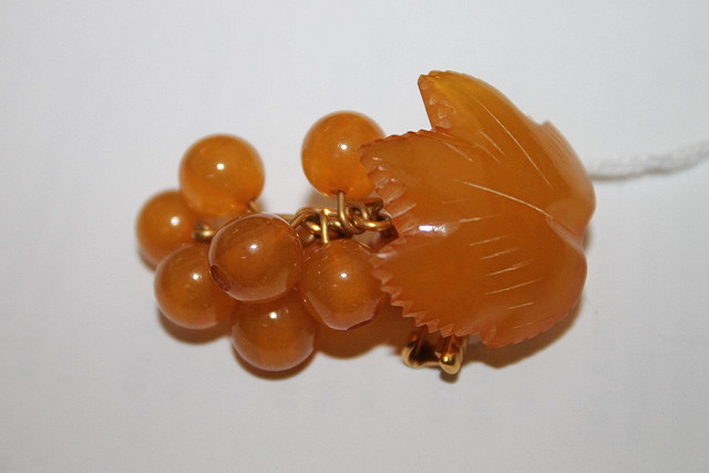 Appraisal: AN AMBER BROOCH of stylised leaf and berry form