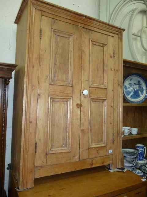 Appraisal: AN ANTIQUE IRISH PINE CUPBOARD with two panelled doors and