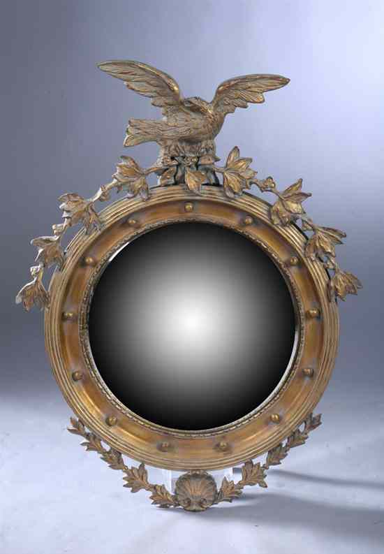 Appraisal: REGENCY STYLE GILT-COMPOSITION BULLS-EYE MIRROR Carved eagle crest round frame