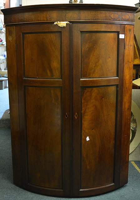 Appraisal: A th Century mahogany bow front corner cupboardwith ebony line