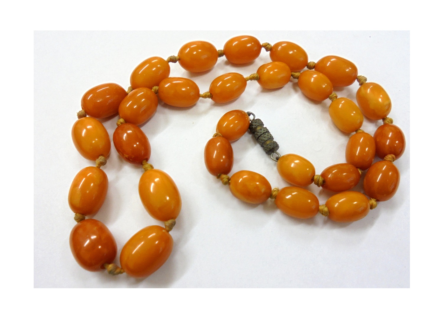 Appraisal: A 'butterscotch' amber oval bead necklace the slightly graduated beads