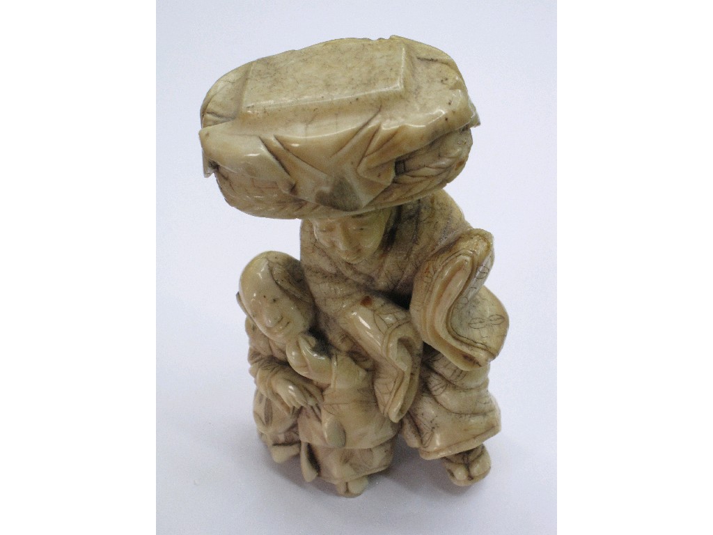 Appraisal: Carved ivory figure man with a boy and basket on