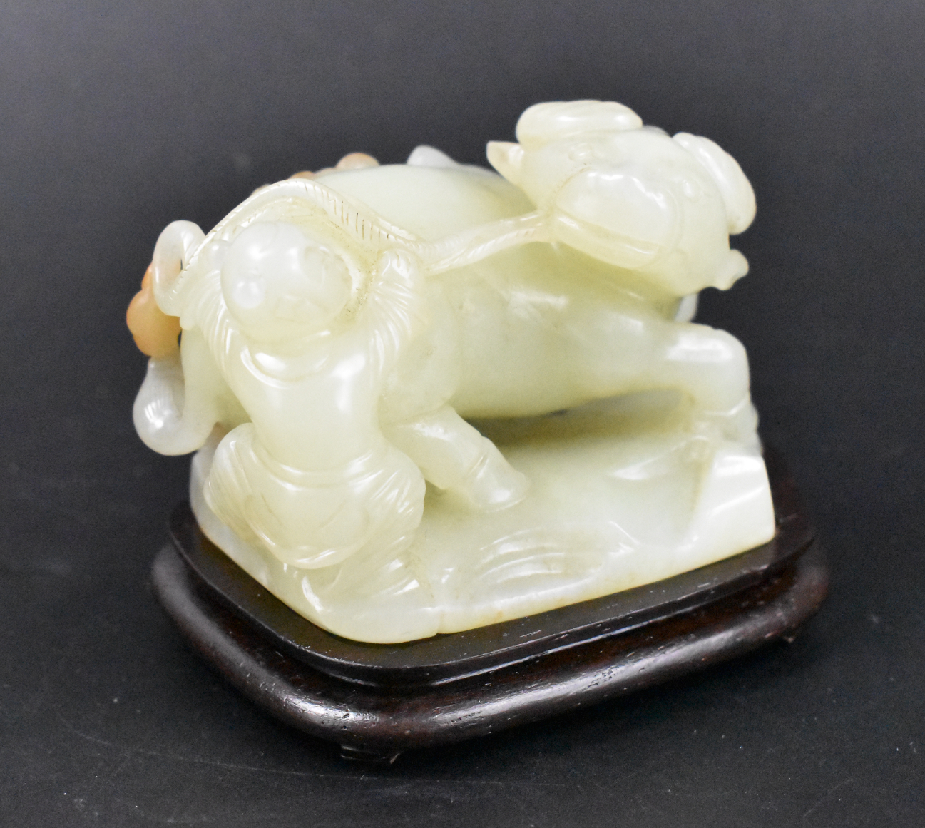 Appraisal: A Chinese jade carving of a boy and a buffalo