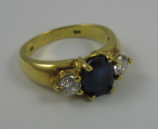 Appraisal: SAPPHIRE DIAMOND AND K GOLD RING centering an oval-cut blue