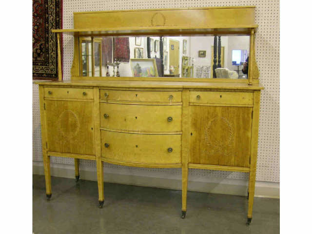 Appraisal: Ca s Maple mirrored back buffet with wreath and ribbon