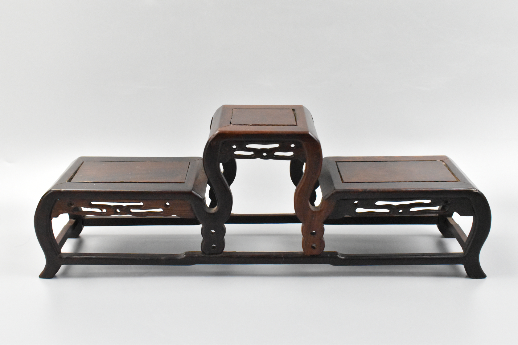 Appraisal: A Chinese wooden carved triple stand A central raised level